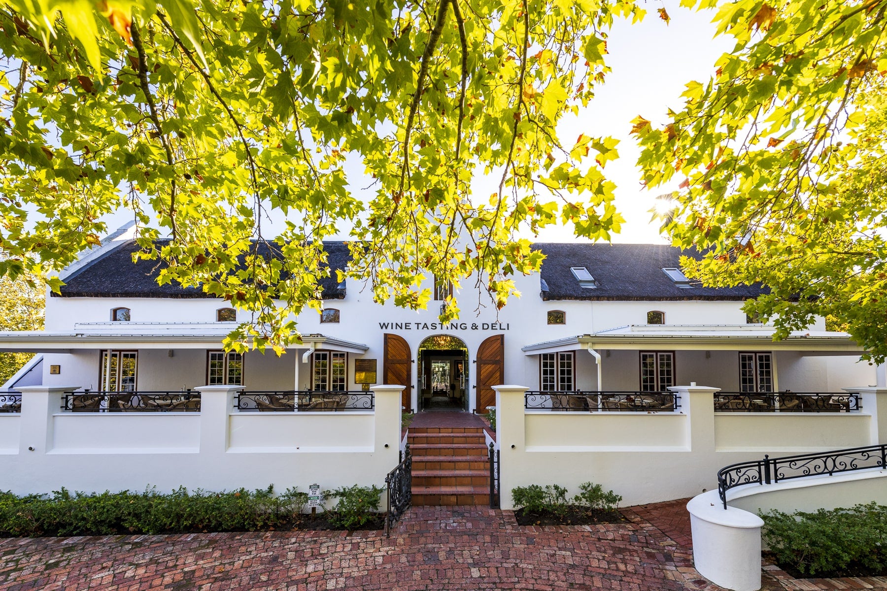 romantische Terasse und Eingang zum historischen Weingut Lanzerac im kapholländischen Architektur-Stil