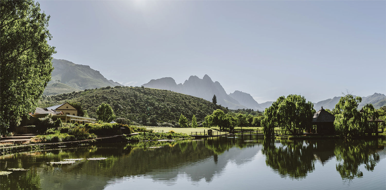 Blick auf einen großen Teich, die Berge von Stellenbosch im Hintergrund
