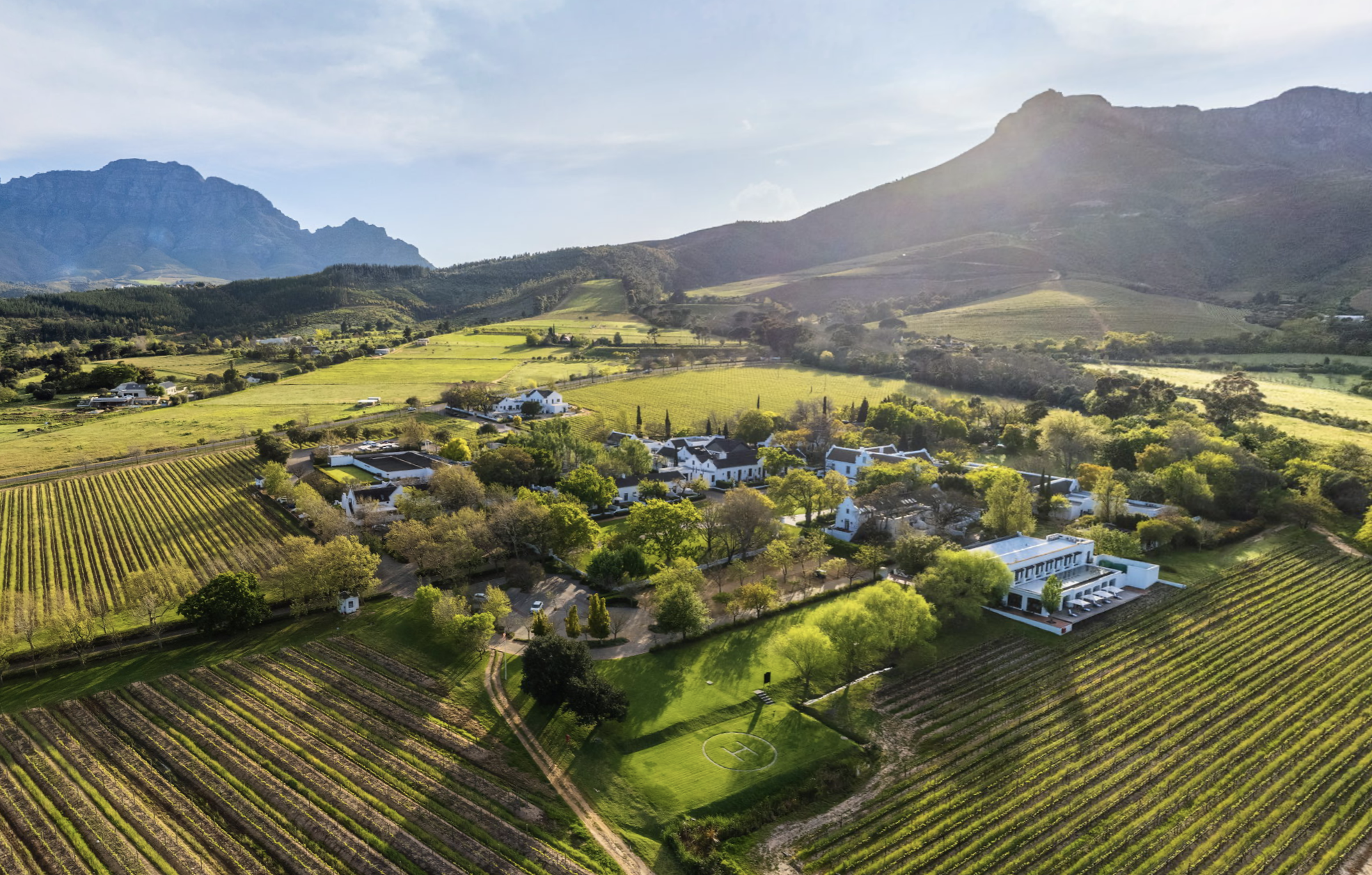 Blick von oben auf das Weingut Lanzerac umgeben von den sanften Hügeln und Weinbergen Stellenboschs